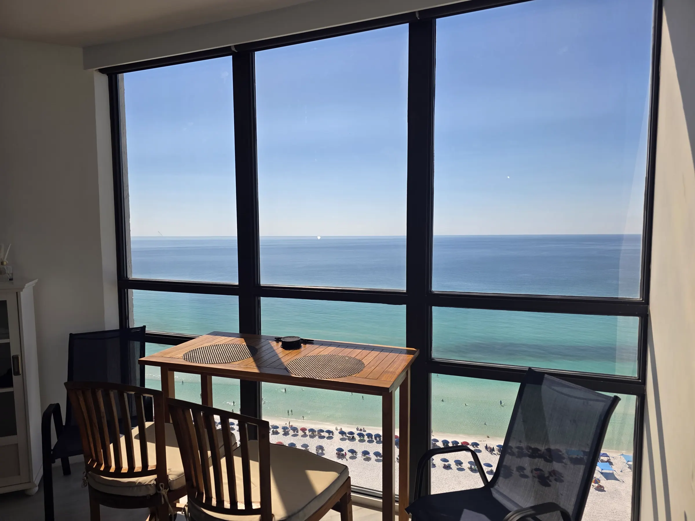 Floor-to-ceiling tinted windows framing the Emerald Coast from a beachfront condo